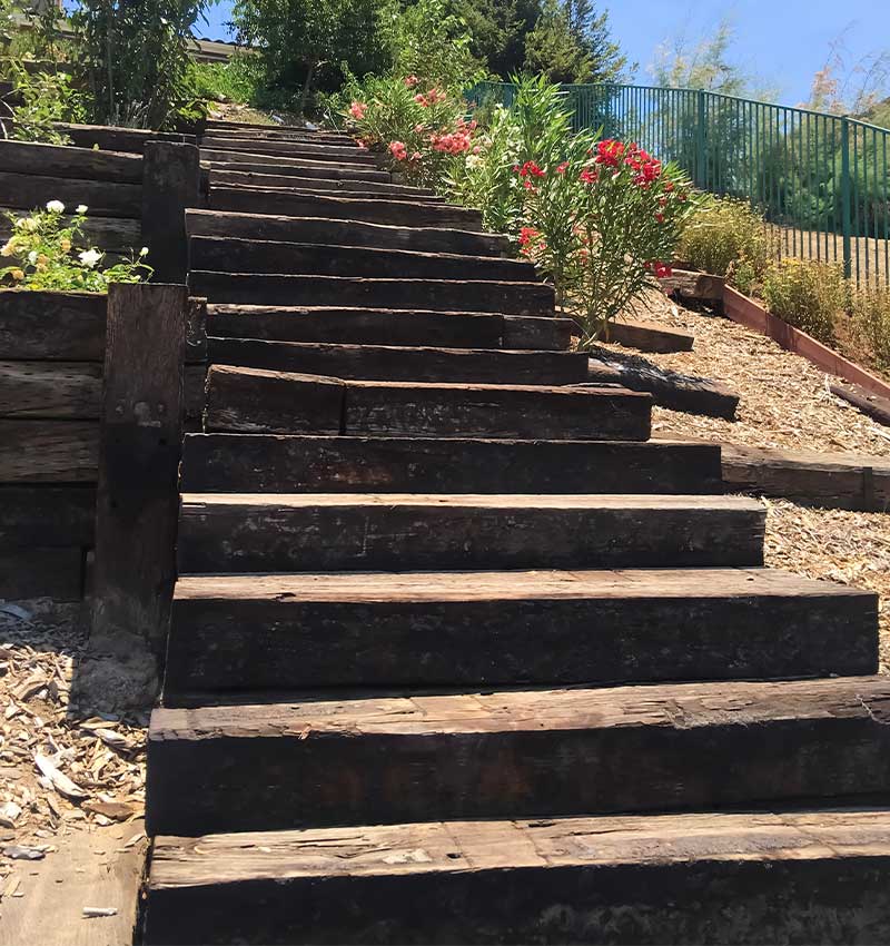 an empty park bench next to a fence